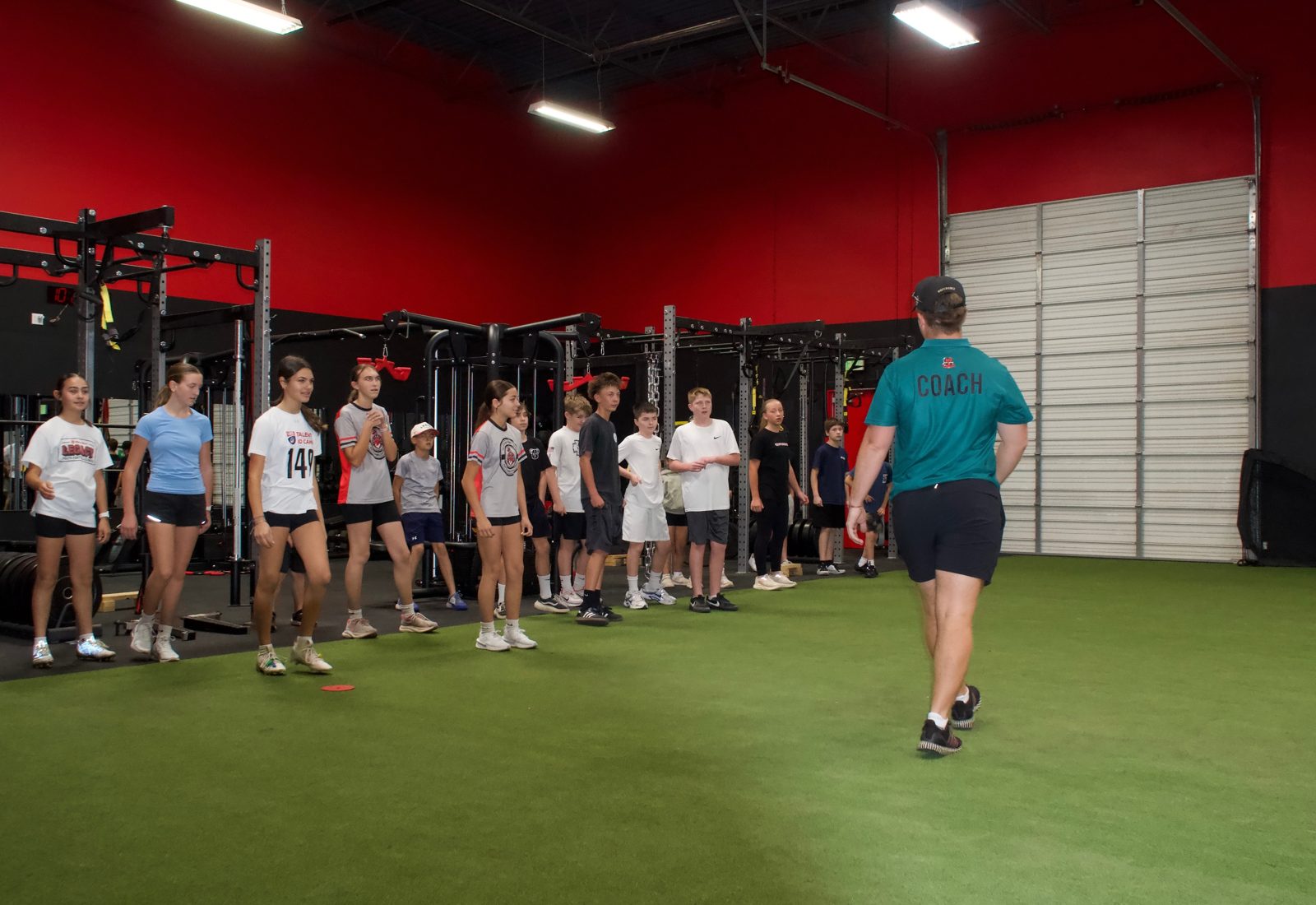 Youth athletes lined up for a coached drill on the turf at A2Z Sports Training in Mesa