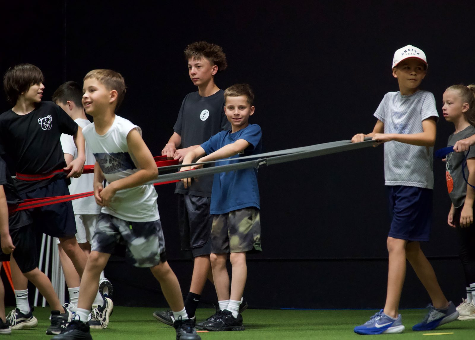 Young athletes pulling on a resistance band during a team drill at A2Z Sports Training